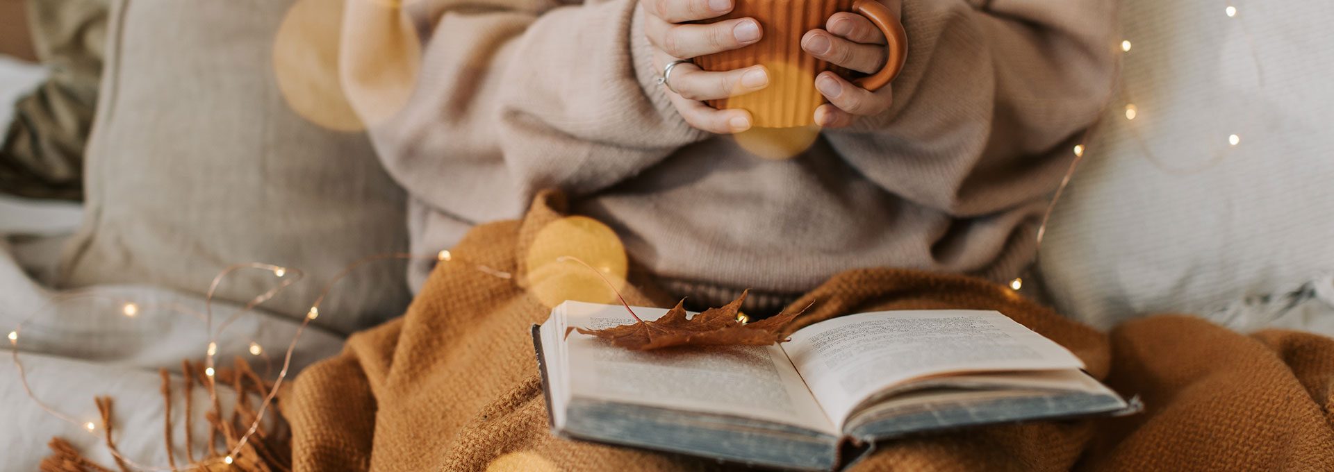 a person reading a book and holding a cup of coffee at The  Brixton